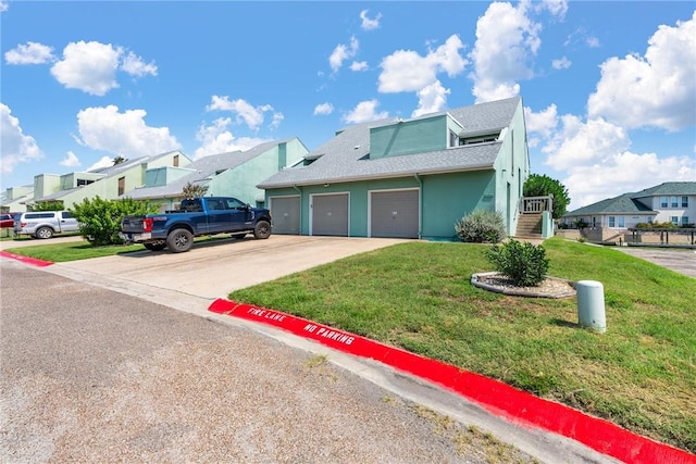 14300 Aloha St N Unit 139, Corpus Christi, TX 78418 - view of front of house with concrete driveway, a front lawn, roof with shingles, a residential view, and stucco siding