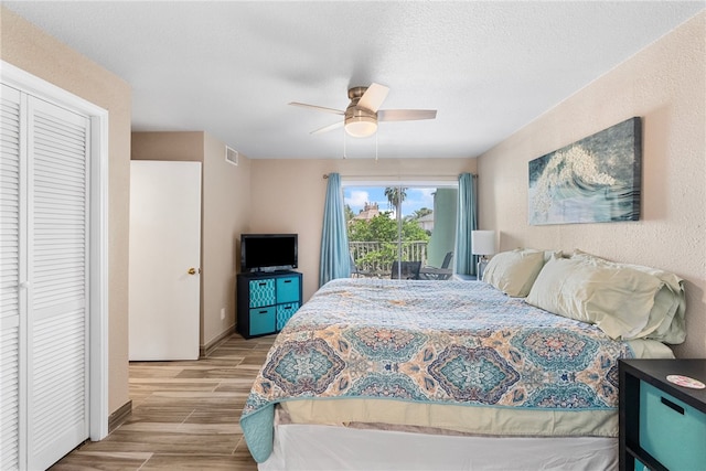 bedroom with a closet, a textured ceiling, access to exterior, light hardwood / wood-style floors, and ceiling fan