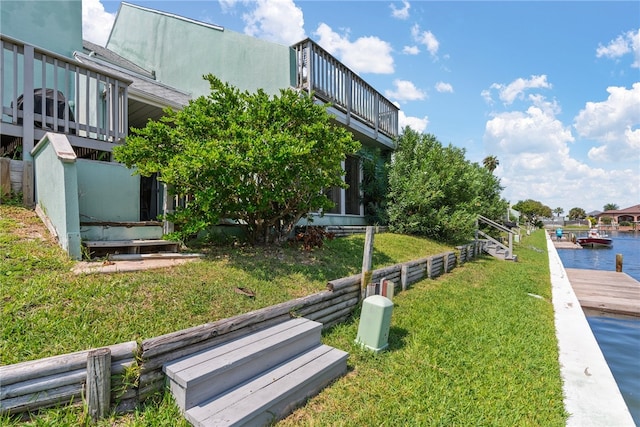 surrounding community with a water view and a lawn