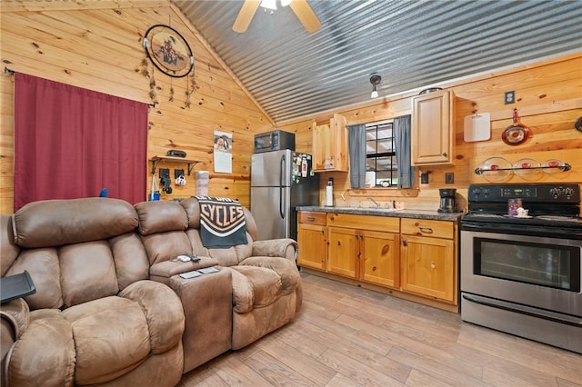 507 S Terry St, Rockport, TX 78382 - kitchen with appliances with stainless steel finishes, open floor plan, wood walls, lofted ceiling, and light wood-style flooring