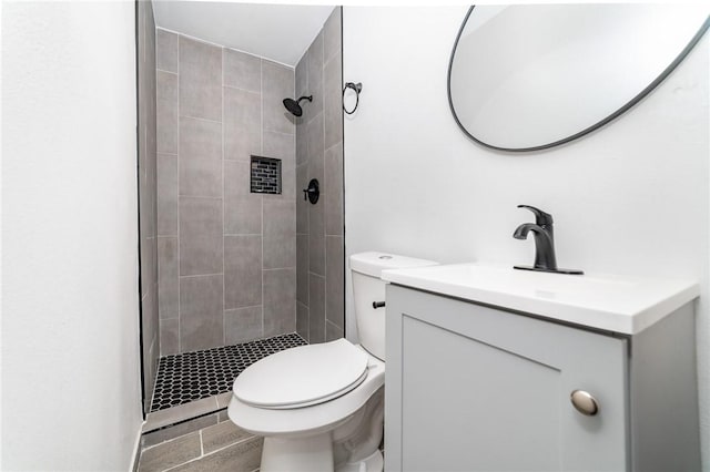 bathroom featuring a stall shower, vanity, and toilet