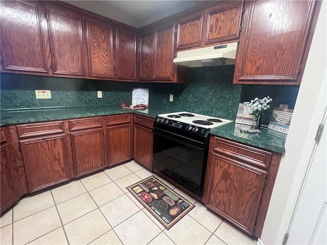 7145 Cano Ln, Corpus Christi, TX 78414 - kitchen with tasteful backsplash, under cabinet range hood, light tile patterned floors, black range with electric stovetop, and dark countertops