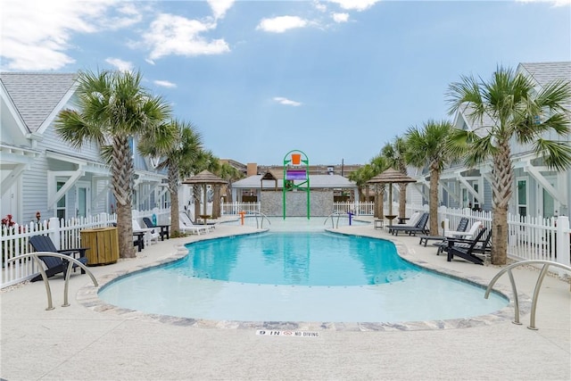 pool with a patio area, fence, and a gazebo