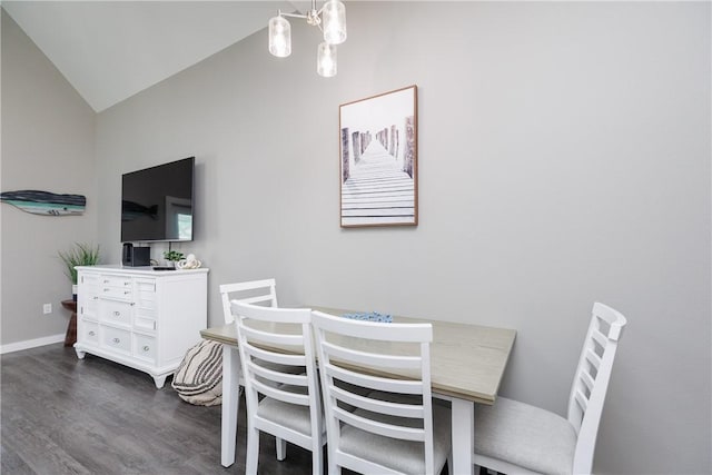 dining space with dark wood-style floors, lofted ceiling, a notable chandelier, and baseboards