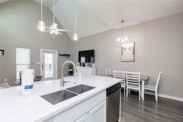 kitchen with decorative light fixtures, light countertops, stainless steel dishwasher, white cabinets, and a sink