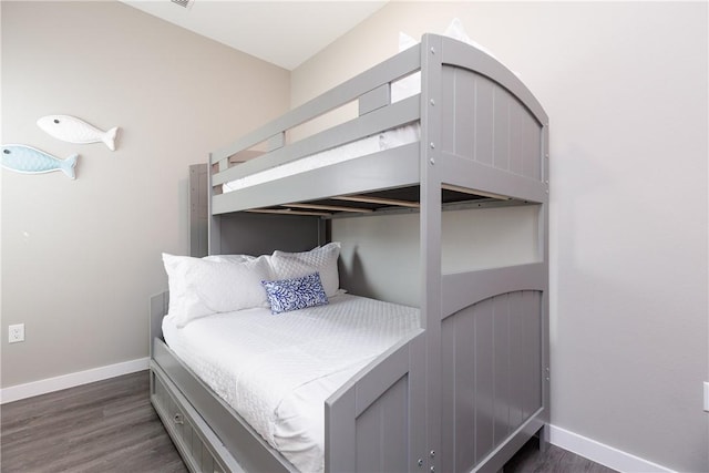 bedroom featuring baseboards and dark wood-type flooring