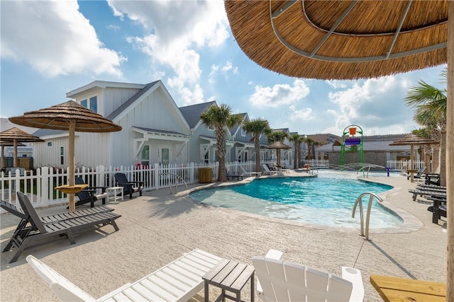 pool featuring a residential view, fence, and a patio