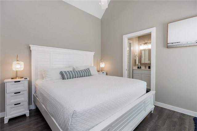 bedroom featuring lofted ceiling, dark wood-style flooring, connected bathroom, and baseboards