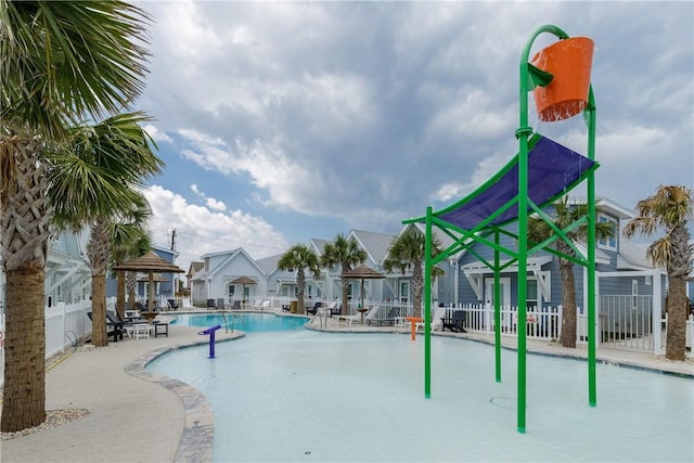 community pool featuring a gazebo, a patio area, fence, and a residential view