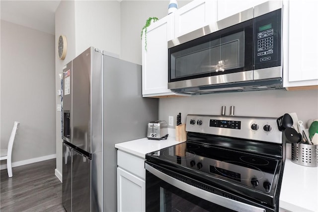 kitchen with appliances with stainless steel finishes, white cabinets, light countertops, and wood finished floors