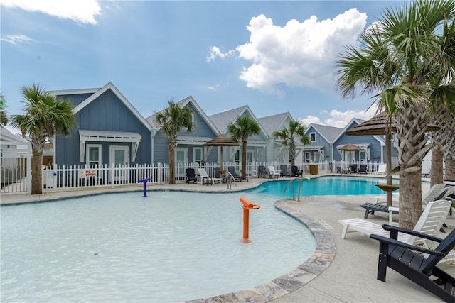 community pool with fence and a patio