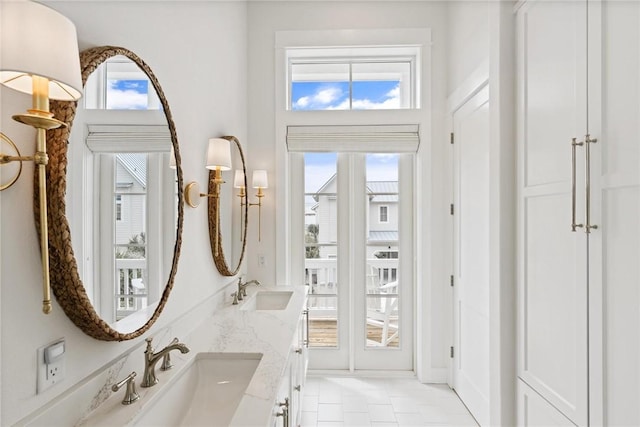 bathroom with a healthy amount of sunlight, double vanity, and a sink