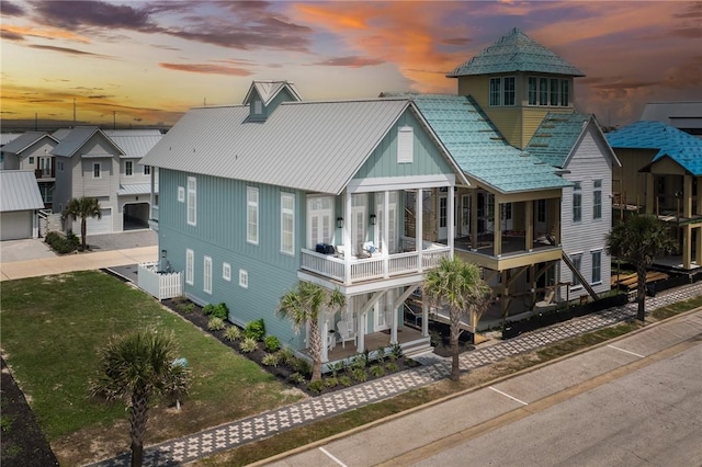 back of house with a balcony, a residential view, and a lawn