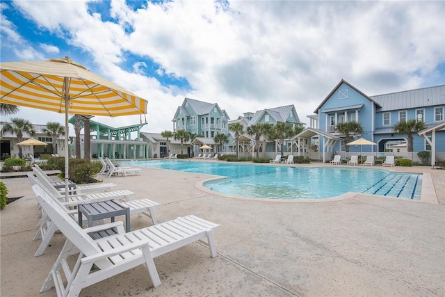 community pool with a residential view and a patio area