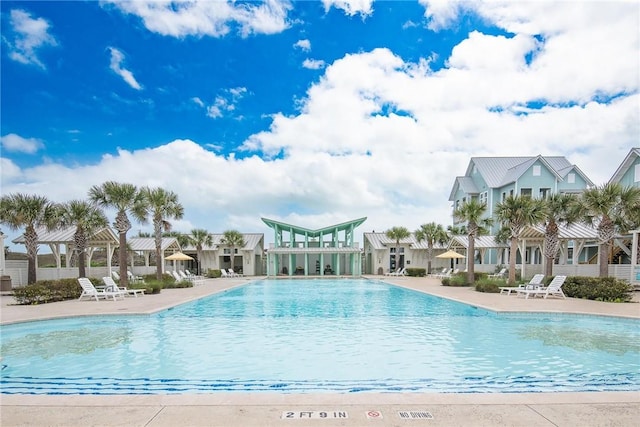 community pool with a residential view and a patio area