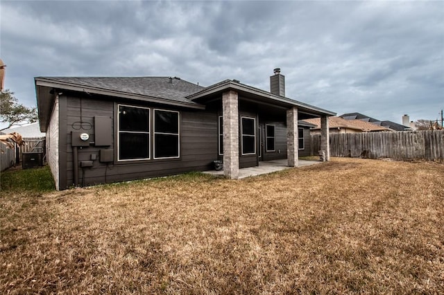 back of house featuring a yard, central AC, and a patio area