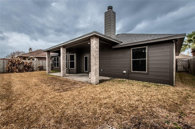 rear view of house featuring a patio and a lawn