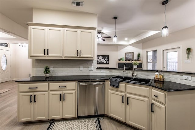 kitchen with pendant lighting, stainless steel dishwasher, a raised ceiling, and cream cabinets