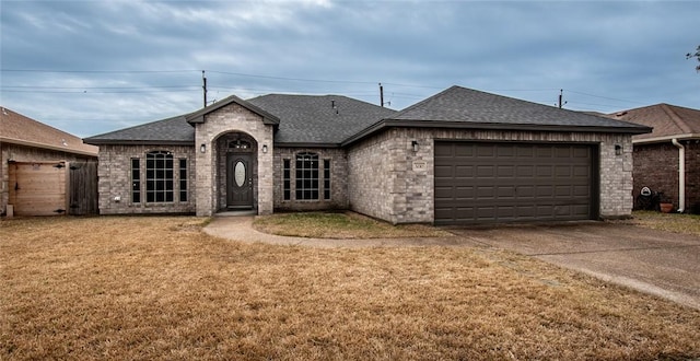 ranch-style house featuring a garage and a front lawn