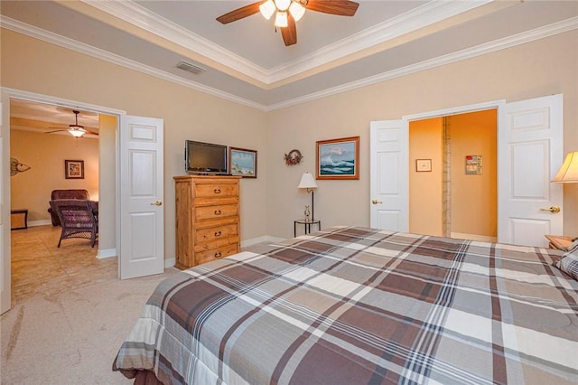 bedroom with light colored carpet, visible vents, baseboards, a raised ceiling, and crown molding