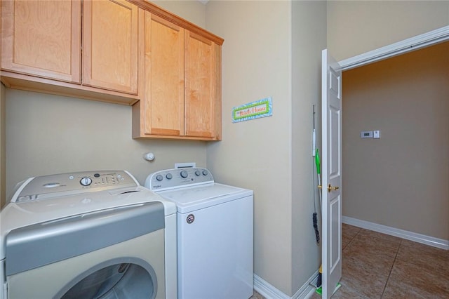 laundry area with baseboards, cabinet space, washing machine and clothes dryer, and tile patterned floors