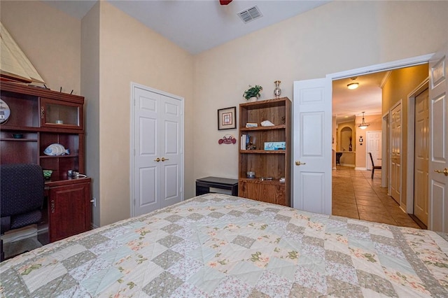 tiled bedroom featuring arched walkways and visible vents