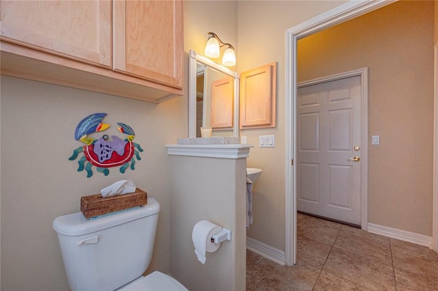 bathroom with tile patterned floors, toilet, and baseboards