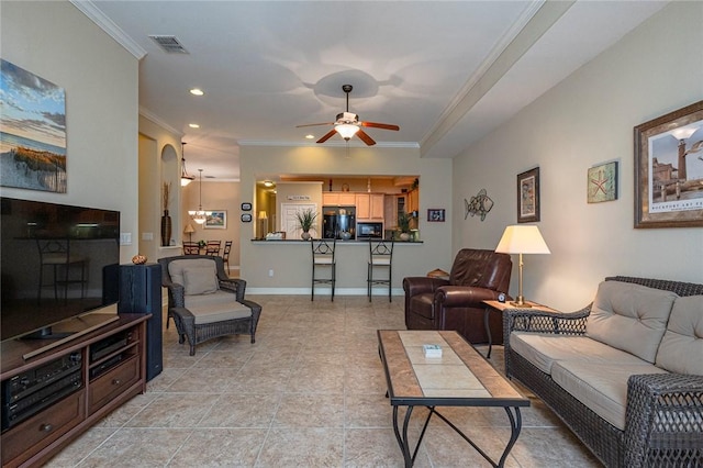 living room featuring arched walkways, ceiling fan, visible vents, baseboards, and crown molding