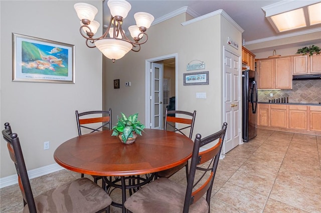 dining space with a notable chandelier, baseboards, crown molding, and light tile patterned flooring