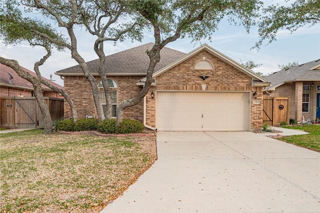 view of front of house with a garage, a gate, concrete driveway, and brick siding