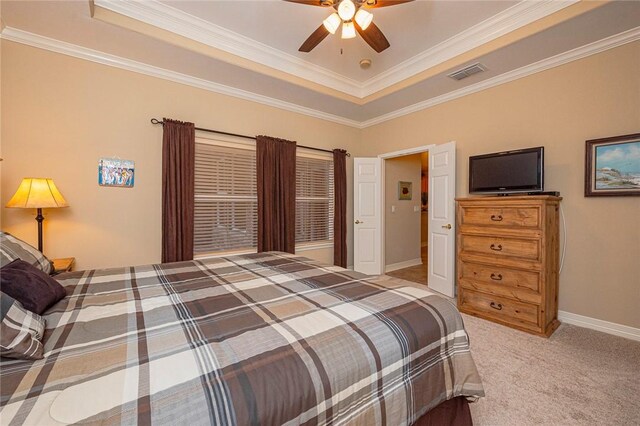 bedroom with ornamental molding, a tray ceiling, visible vents, and light colored carpet