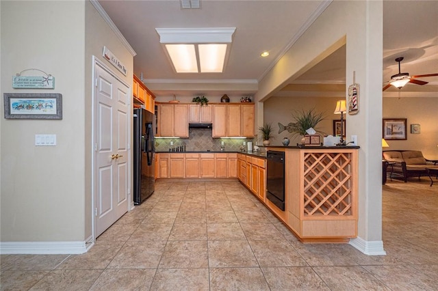 kitchen with black appliances, ornamental molding, dark countertops, and light brown cabinets