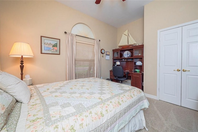 carpeted bedroom with a ceiling fan, a closet, and baseboards