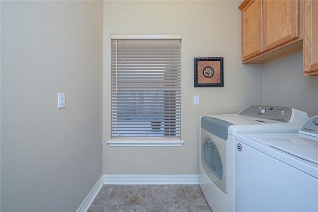 washroom with cabinet space, washing machine and dryer, and baseboards