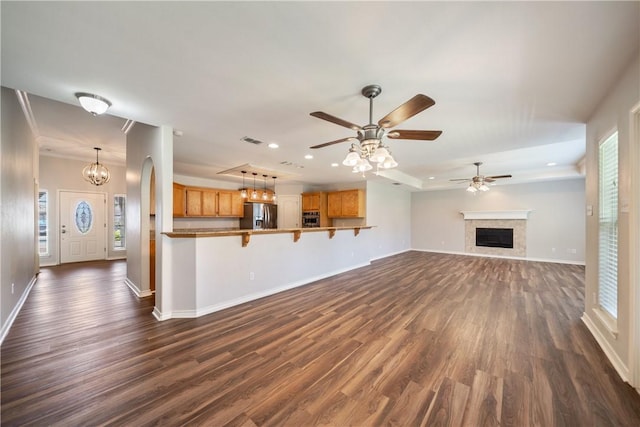 2602 Windhollow Dr, Corpus Christi, TX 78414 - unfurnished living room featuring dark wood-style floors, a ceiling fan, recessed lighting, a fireplace, and a raised ceiling