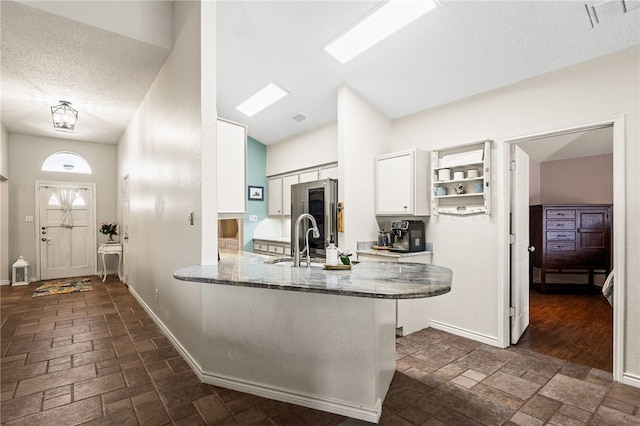 13853 Topsail St, Corpus Christi, TX 78418 - kitchen featuring smart refrigerator, stone counters, white cabinets, a peninsula, and vaulted ceiling