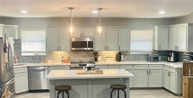 kitchen with a breakfast bar area, appliances with stainless steel finishes, and tasteful backsplash