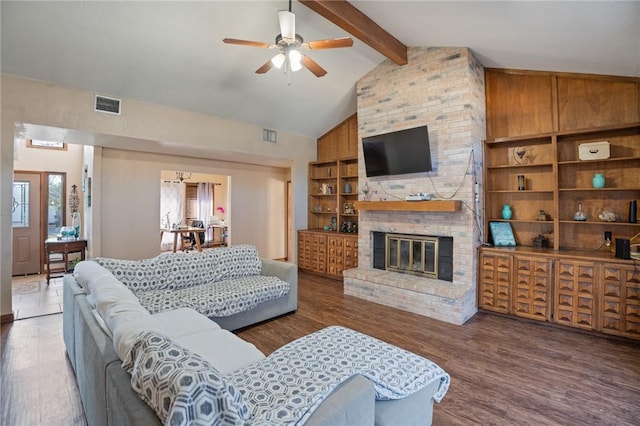 living room with beamed ceiling, dark wood-type flooring, a fireplace, and built in shelves