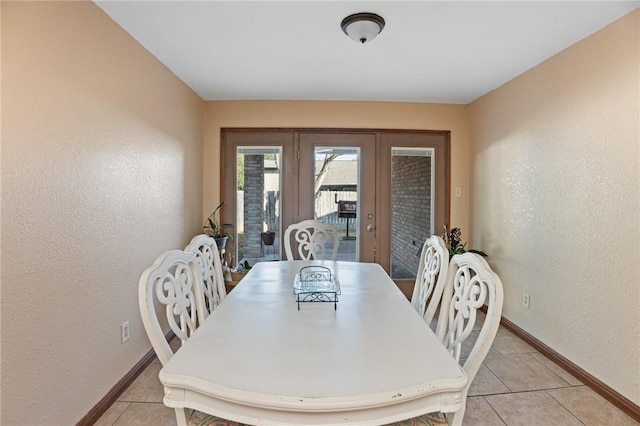 tiled dining room featuring french doors