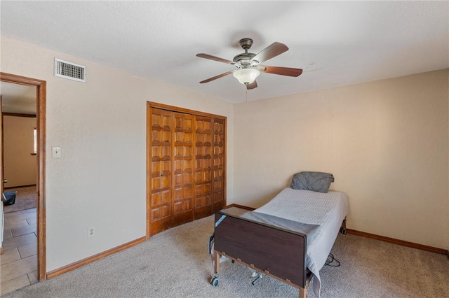 carpeted bedroom with ceiling fan and a closet