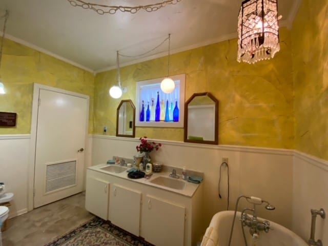 bathroom with a tub, a chandelier, toilet, and ornamental molding