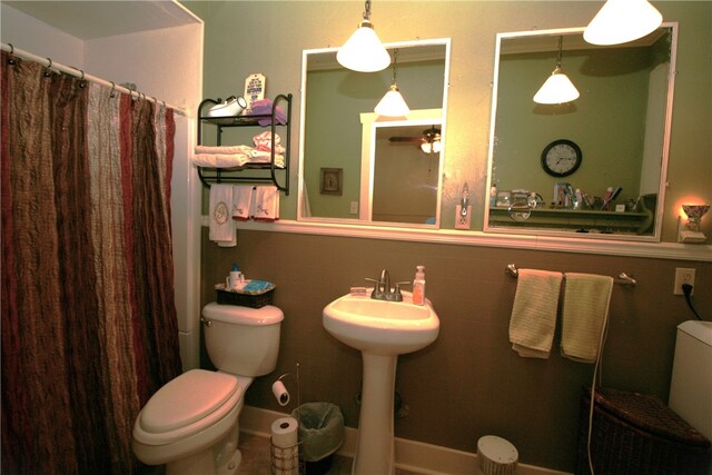 bathroom featuring a shower with curtain, toilet, tile walls, and sink