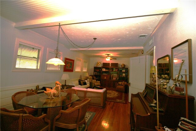 dining area with ornamental molding, dark hardwood / wood-style flooring, beamed ceiling, and ceiling fan