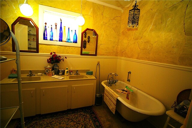 bathroom featuring sink, ornamental molding, and a bathing tub