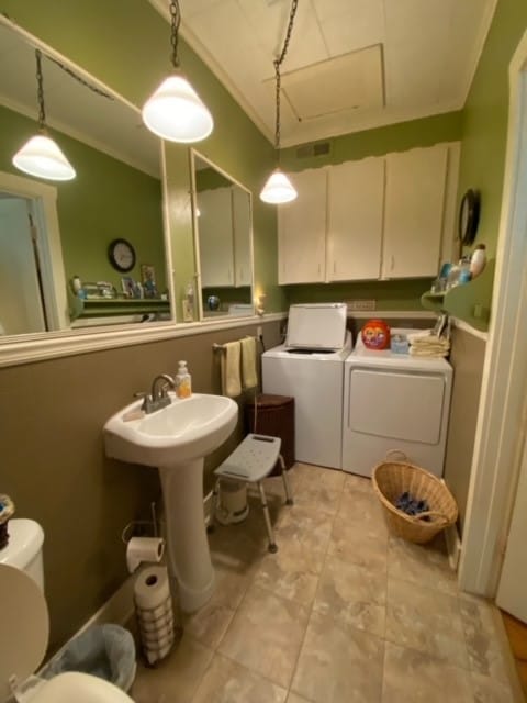 bathroom featuring toilet, washing machine and dryer, sink, and ornamental molding