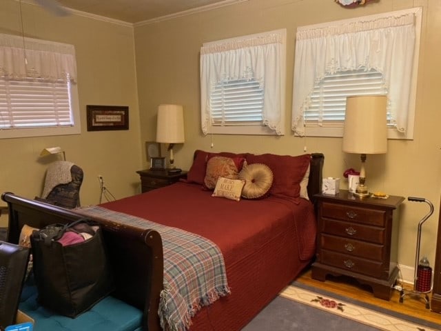 bedroom with hardwood / wood-style flooring and ornamental molding