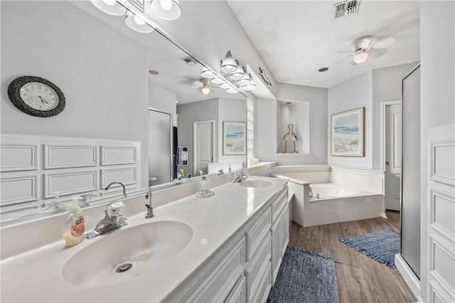 bathroom featuring ceiling fan, a washtub, vanity, and hardwood / wood-style flooring