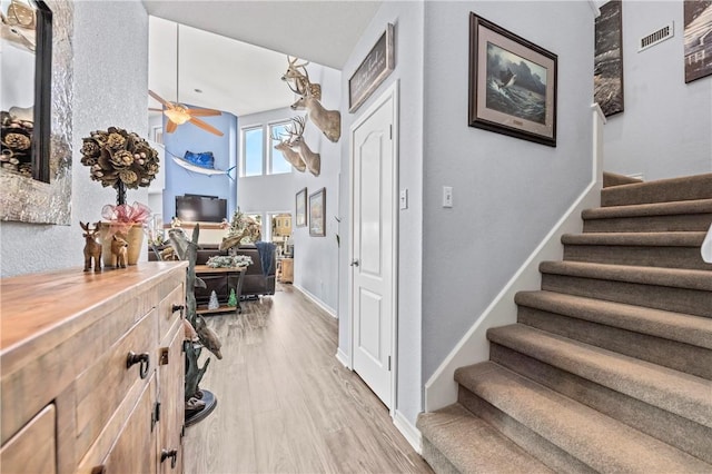 interior space with a towering ceiling and light hardwood / wood-style floors