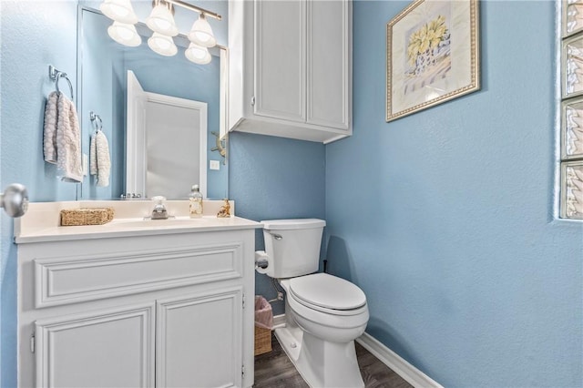 bathroom with hardwood / wood-style floors, vanity, and toilet