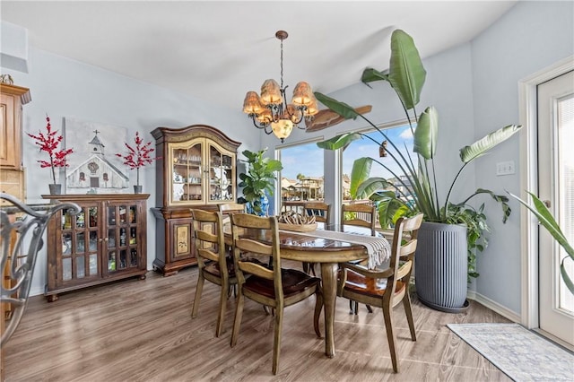 dining room with an inviting chandelier and light hardwood / wood-style flooring